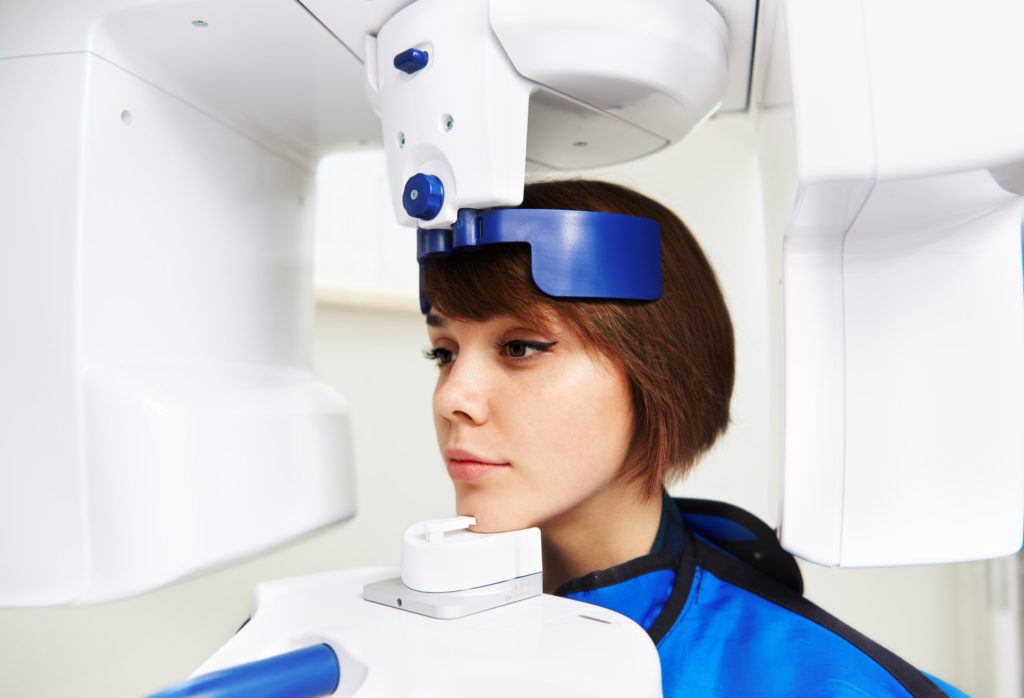Close-up of woman patient doing panoramic teeth X-ray in dental clinic.