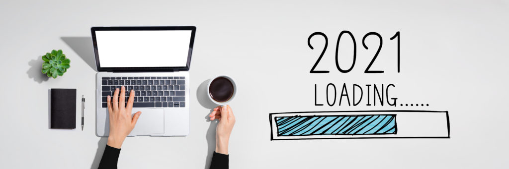 Overhead shot of a person’s hands with coffee and a laptop, and a graphic of a loading bar with the words “2021 loading.