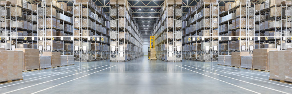 Huge distribution warehouse with high shelves and loaders.