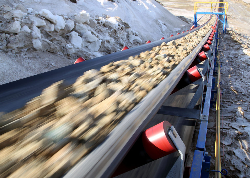Conveyor belt in motion carrying raw materials from a mine.