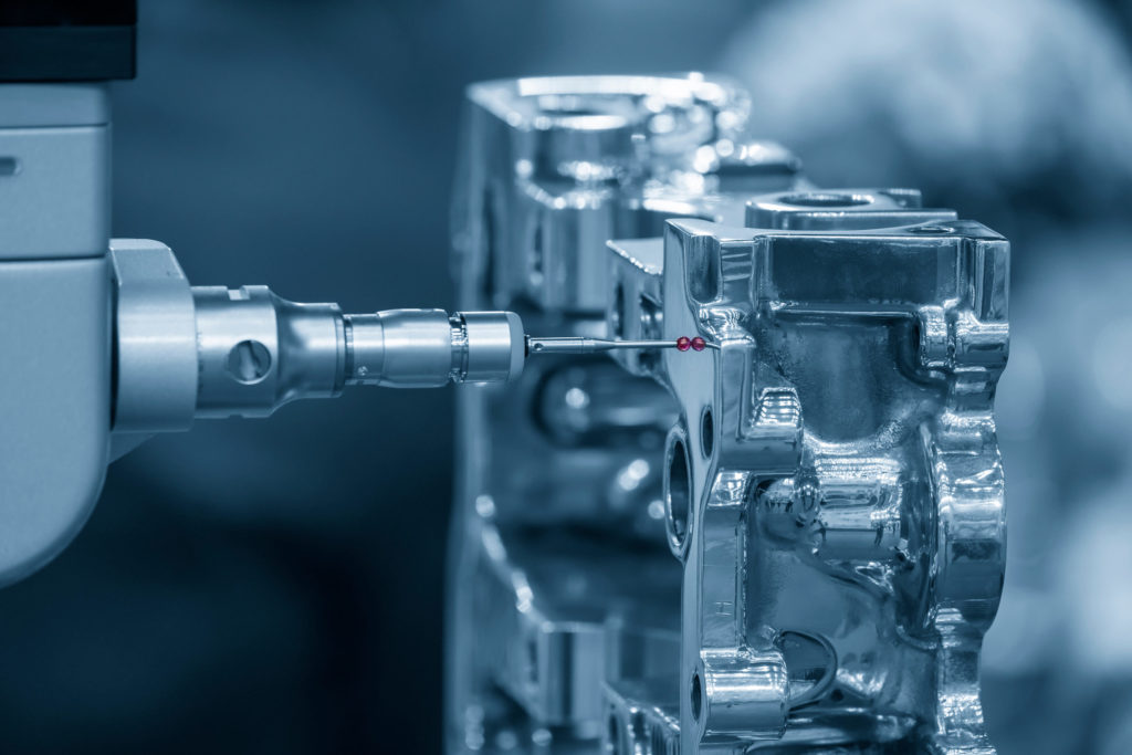 Multi-axis CMM machine checking the aluminum cylinder block parts.